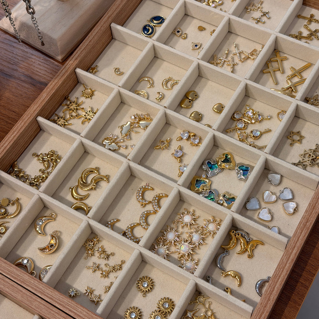 Jewelry display case with various charms organized in compartments.